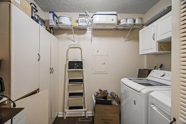 laundry room with dark wood-type flooring, independent washer and dryer, cabinets, electric panel, and a textured ceiling