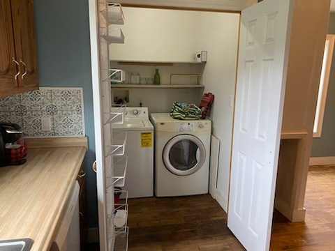 laundry area featuring washing machine and dryer and dark hardwood / wood-style flooring