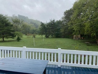 wooden deck featuring a lawn