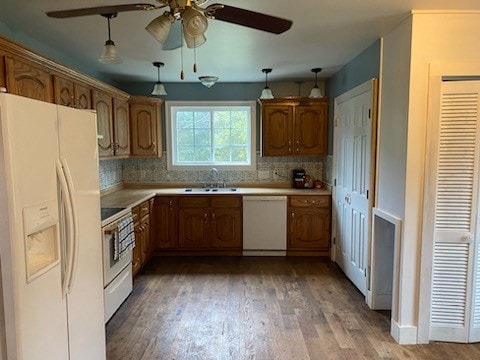 kitchen with decorative light fixtures, hardwood / wood-style floors, sink, and white appliances