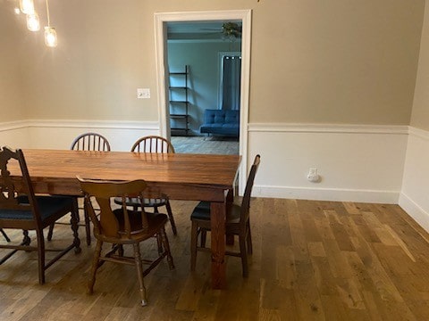 dining space with ceiling fan and dark wood-type flooring