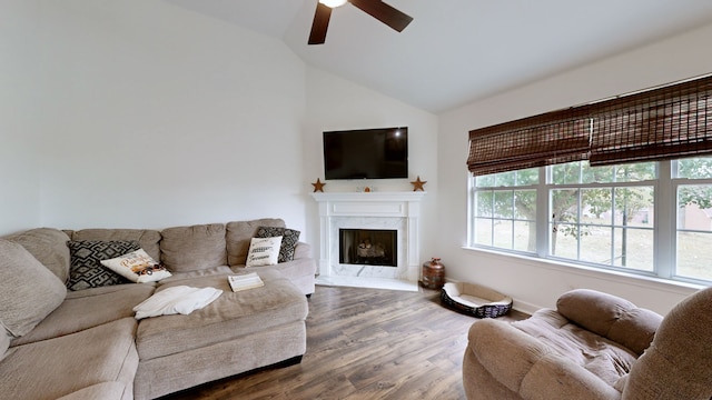 living room featuring wood-type flooring, lofted ceiling, a fireplace, and ceiling fan