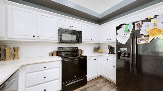 kitchen featuring light stone countertops, black appliances, white cabinetry, and dark wood-type flooring