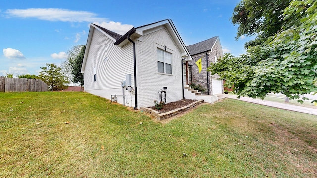 view of side of property featuring a garage and a yard