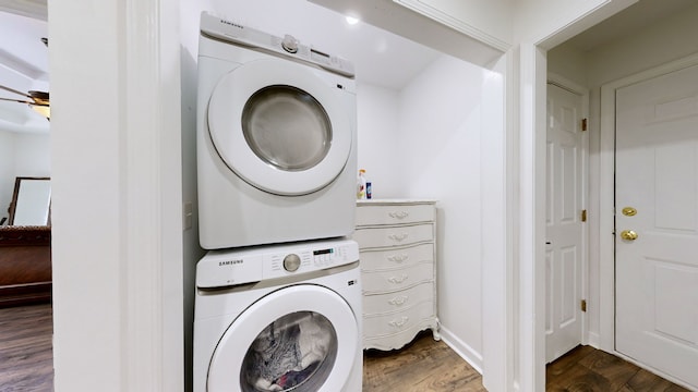 laundry room with stacked washer / dryer and hardwood / wood-style flooring