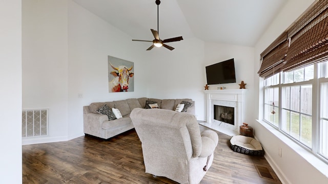 living room with ceiling fan, dark hardwood / wood-style flooring, a high end fireplace, and high vaulted ceiling