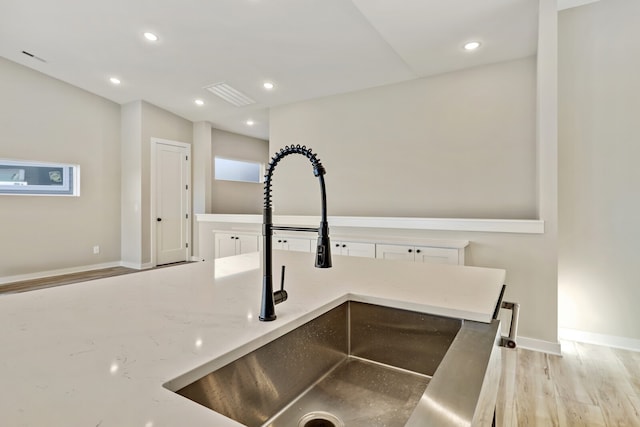 kitchen with white cabinetry, light hardwood / wood-style floors, and sink