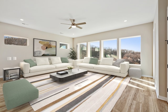 living room with light hardwood / wood-style flooring and ceiling fan