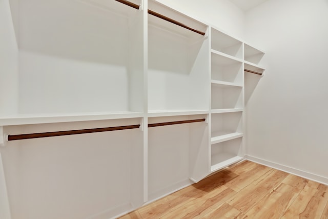 walk in closet with hardwood / wood-style flooring