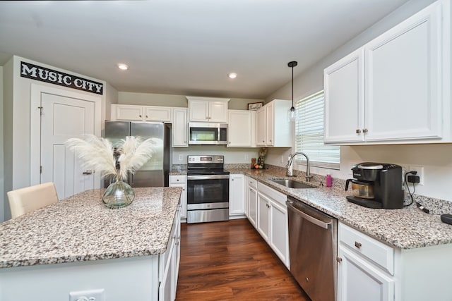 kitchen featuring a center island, dark hardwood / wood-style floors, sink, white cabinetry, and appliances with stainless steel finishes