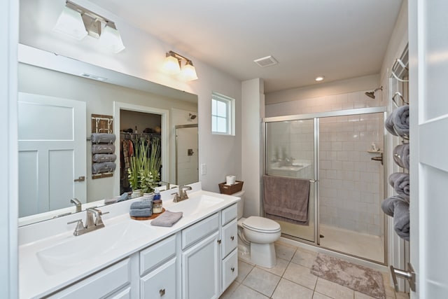 bathroom with tile patterned floors, walk in shower, vanity, and toilet