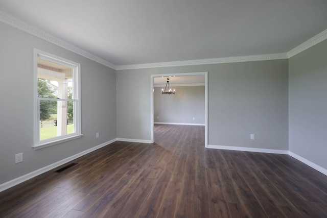 spare room featuring a chandelier, dark hardwood / wood-style flooring, and ornamental molding