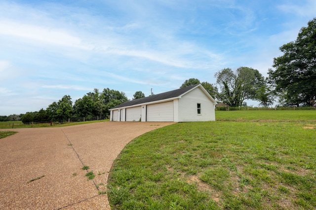 view of home's exterior with a yard, an outbuilding, and a garage