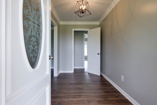 entryway with dark hardwood / wood-style floors, ornamental molding, and an inviting chandelier