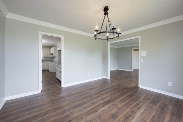 empty room featuring dark hardwood / wood-style floors, crown molding, and a notable chandelier