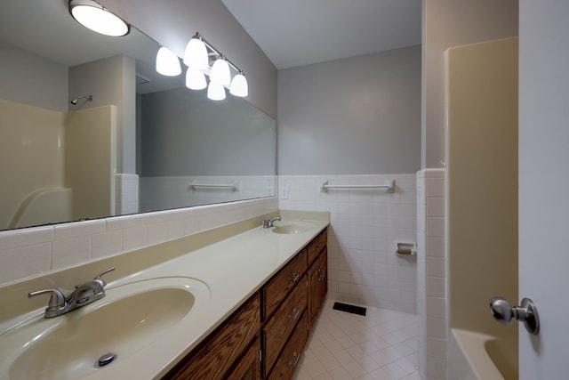 bathroom with tile patterned flooring, vanity, and tile walls