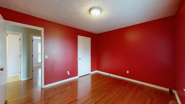 unfurnished bedroom with a textured ceiling and hardwood / wood-style floors