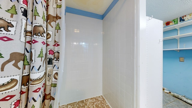 bathroom featuring walk in shower and a textured ceiling