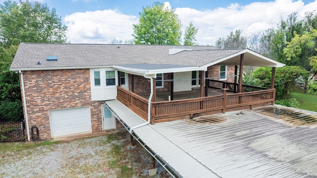 rear view of house featuring a deck and a garage