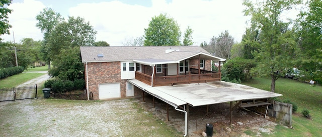 back of property featuring a garage and a wooden deck