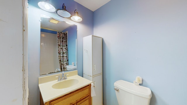 bathroom featuring vanity, toilet, and a shower with shower curtain