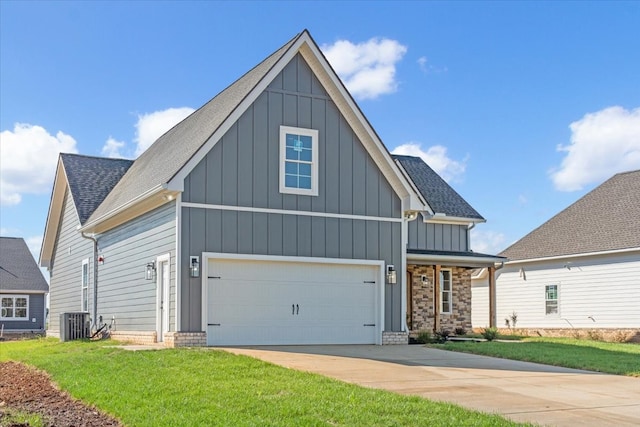 view of front of house featuring a front yard, a garage, and central AC unit