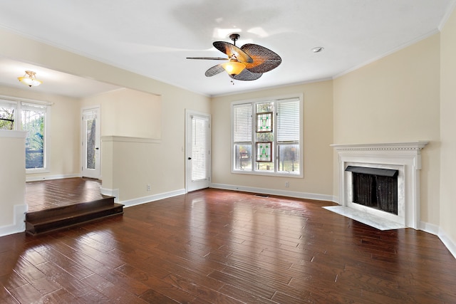 unfurnished living room with a wealth of natural light, ceiling fan, dark hardwood / wood-style floors, and ornamental molding