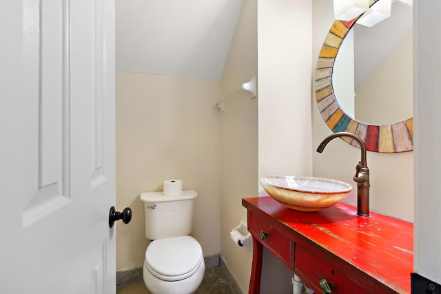 bathroom featuring vaulted ceiling, vanity, and toilet