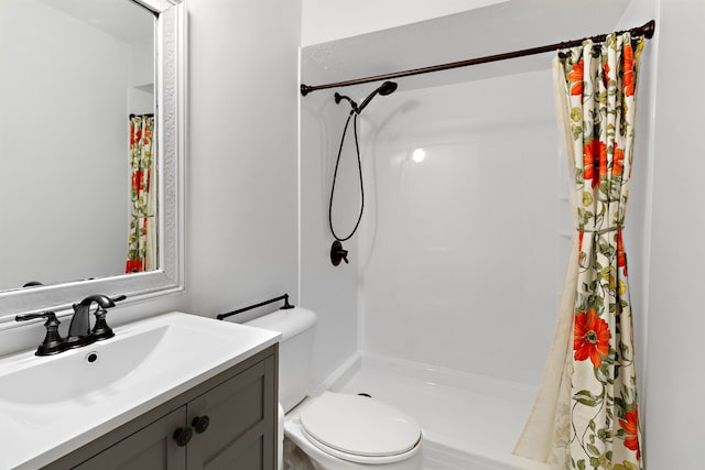 bathroom with walk in shower, vanity, and toilet