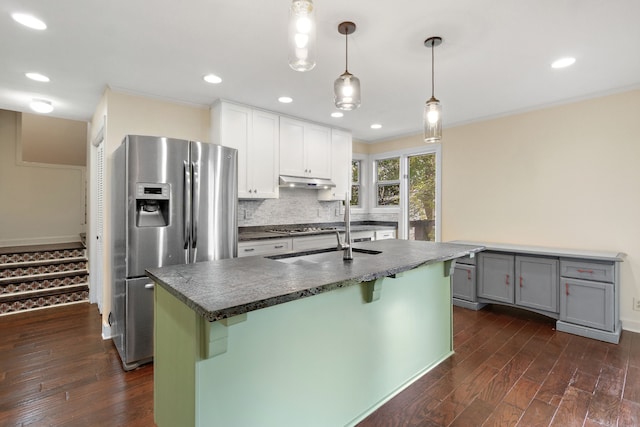 kitchen with white cabinetry, tasteful backsplash, hanging light fixtures, dark hardwood / wood-style floors, and stainless steel appliances