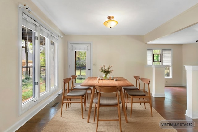 dining space with dark hardwood / wood-style floors and a healthy amount of sunlight