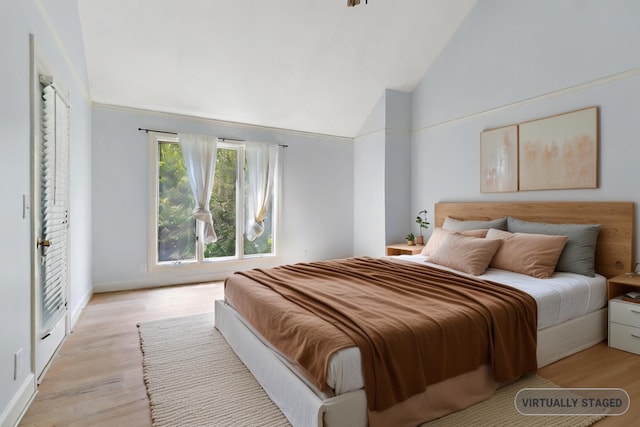 bedroom with high vaulted ceiling and light wood-type flooring