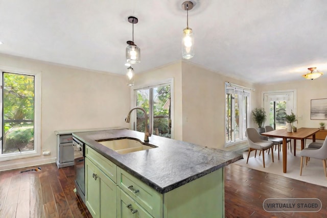 kitchen with sink, a center island with sink, hanging light fixtures, plenty of natural light, and green cabinets