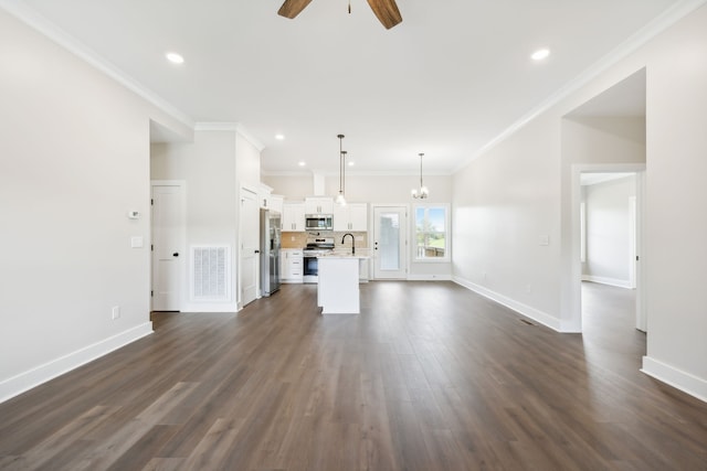 unfurnished living room featuring ornamental molding, ceiling fan with notable chandelier, dark hardwood / wood-style floors, and sink