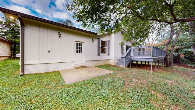 rear view of property with a wooden deck and a lawn