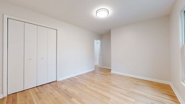 unfurnished bedroom with light hardwood / wood-style flooring and a closet