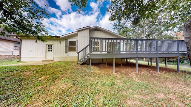 rear view of house with a wooden deck and a yard