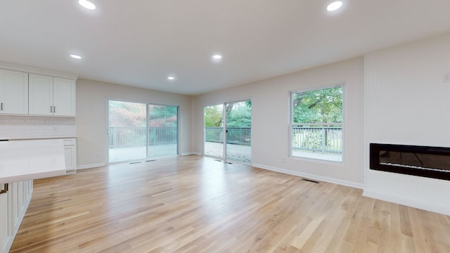 unfurnished living room featuring light hardwood / wood-style floors and plenty of natural light