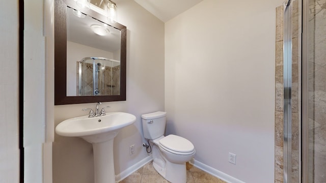 bathroom featuring sink, a shower with door, tile patterned floors, and toilet