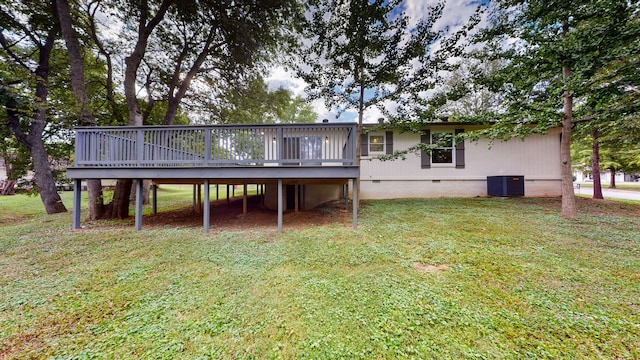 rear view of property with a yard, central air condition unit, and a wooden deck