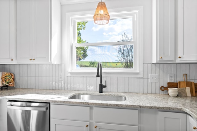 kitchen featuring dishwasher, sink, white cabinetry, decorative light fixtures, and light stone countertops