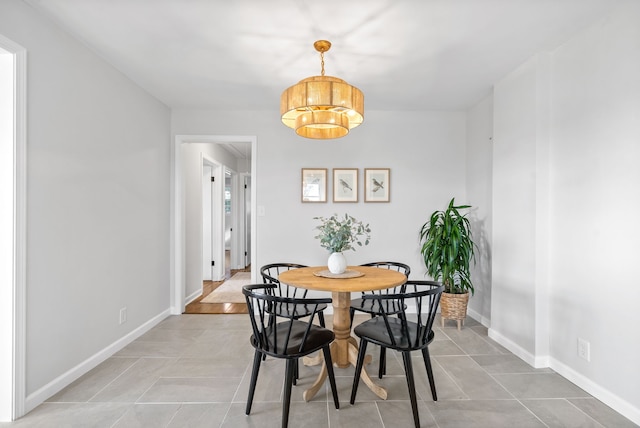 tiled dining area with an inviting chandelier