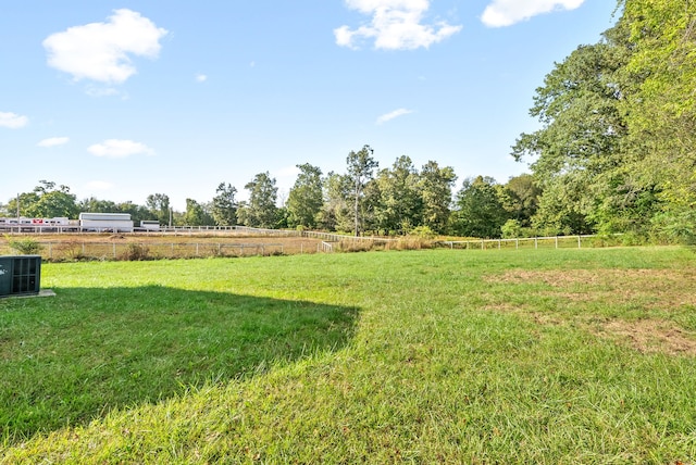 view of yard featuring a rural view and central air condition unit