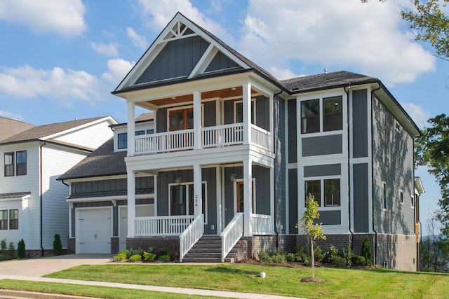 view of front of property featuring a front yard, a balcony, a garage, and covered porch