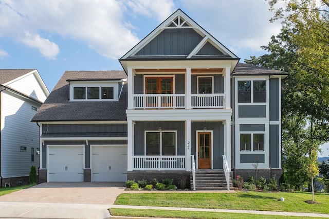 craftsman inspired home featuring a front yard, a garage, and a balcony