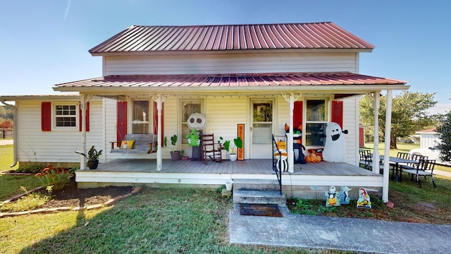 rear view of house with a lawn and covered porch