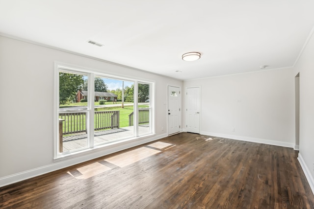 spare room with ornamental molding and dark wood-type flooring