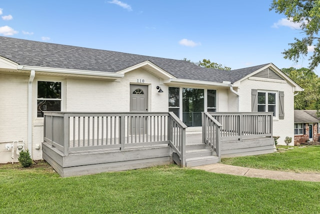 view of front facade with a wooden deck and a front yard