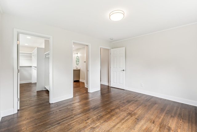 unfurnished bedroom with a closet, dark hardwood / wood-style floors, and a spacious closet