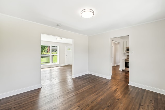 empty room with crown molding and dark hardwood / wood-style floors